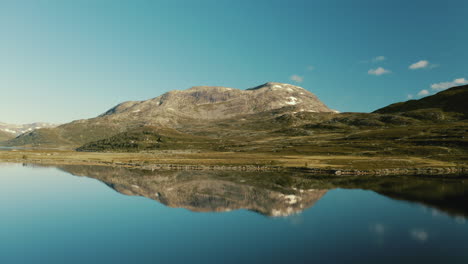 Drone-Flying-Backward-Revealing-The-Supreme-Reflective-View-Of-The-Majestic-Mountain-In-Lake-Vavatnet-In-Norway---pullback-shot