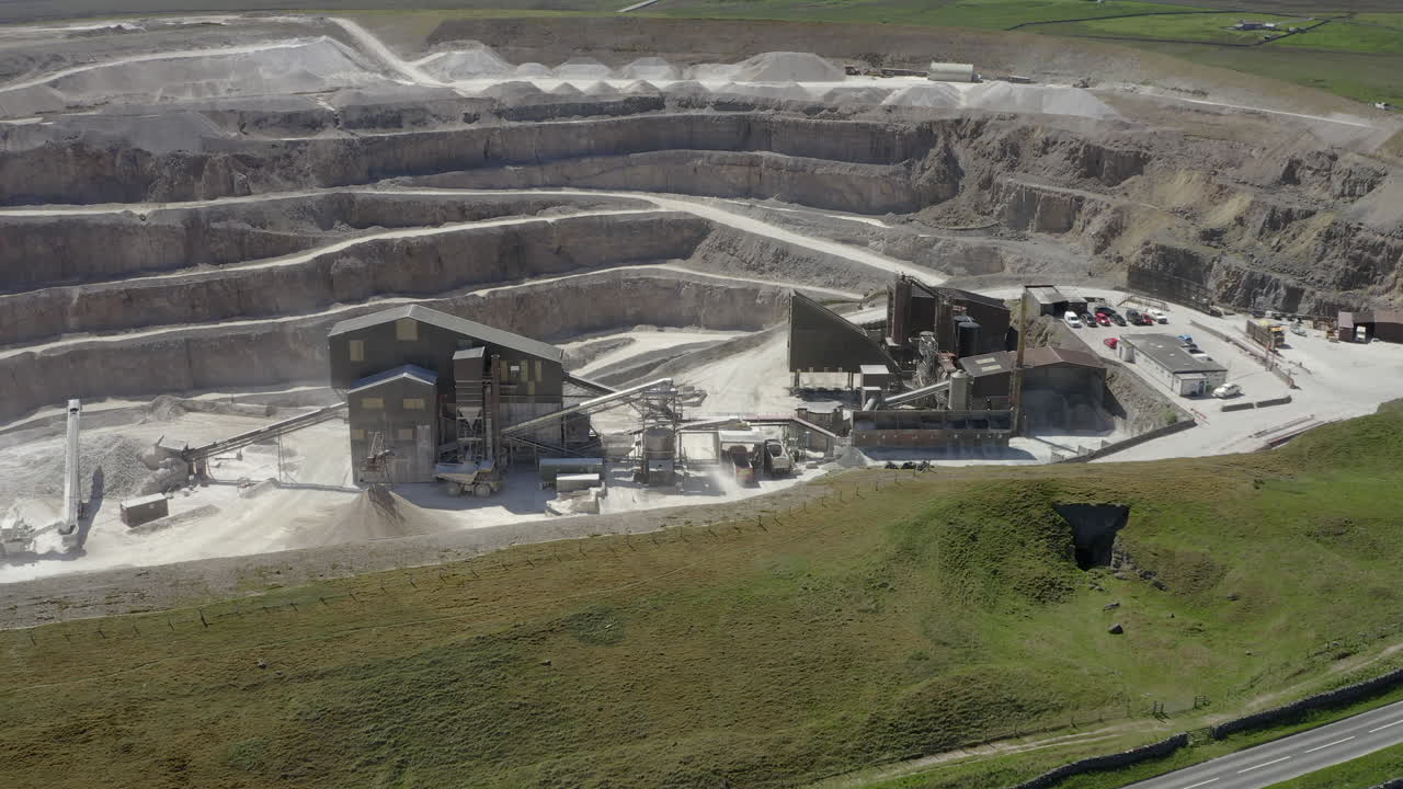 An aerial view of a working asphalt quarry building with the quarry cut in the background, Yorkshire, UK