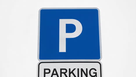 a close-up of a blue and white parking sign