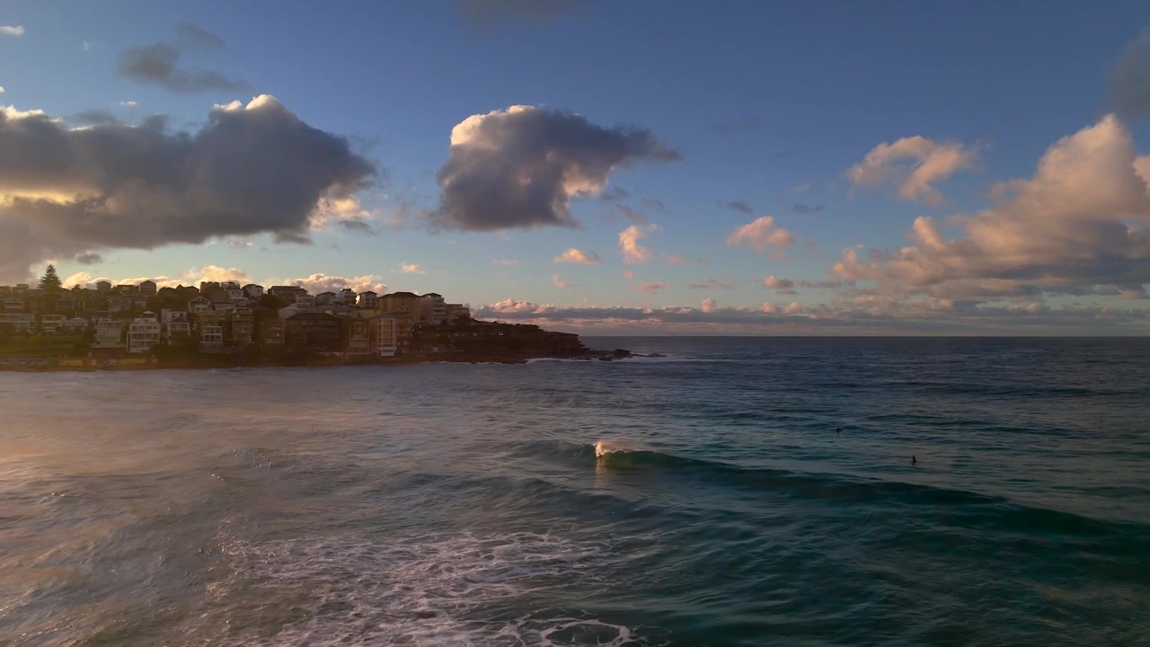 Bondi Beach al mattino presto con un cielo spettacolare e suggestivo prima dell'alba. La telecamera si muove verso nord tra nebbia e spruzzi marini