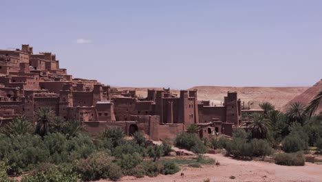 exploring the sunny sand city of ait ben haddou in morocco, with a panoramic view over sand houses, fortresses, and scenic monuments in the middle of the dessert