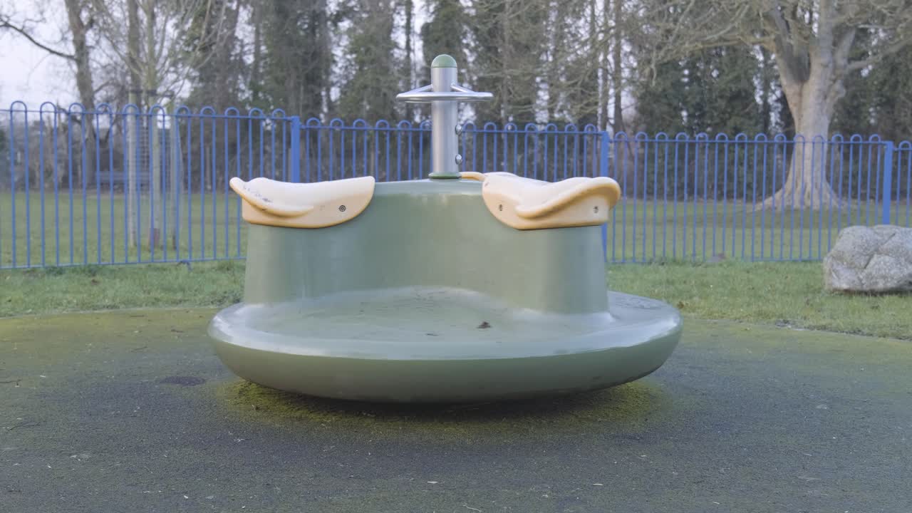 춥고 흐린 날 런던 중심가에서 느린 동작으로 회전하는 회전목마가 있는 빈 어린이 놀이터