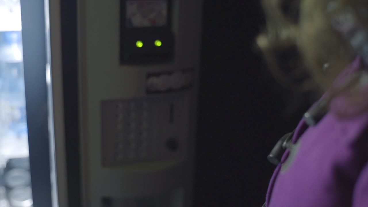 persona que utiliza una máquina expendedora por la noche