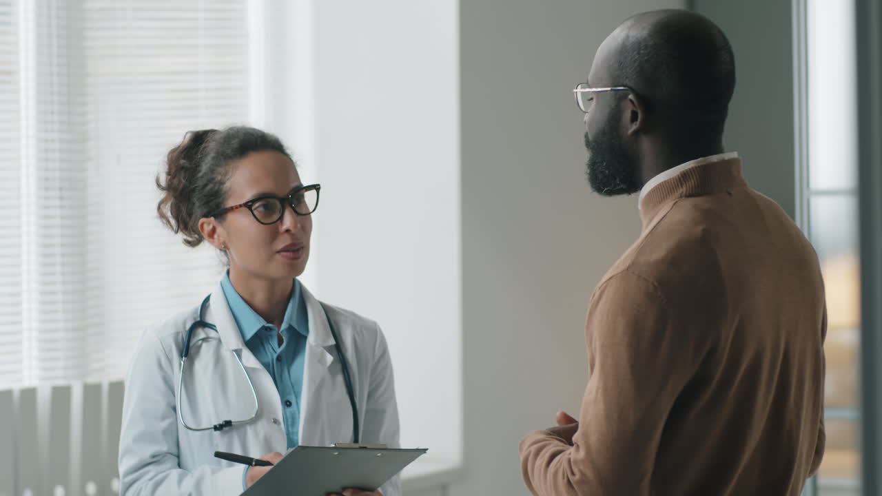 Female Doctor Talking with African American Patient in Clinic