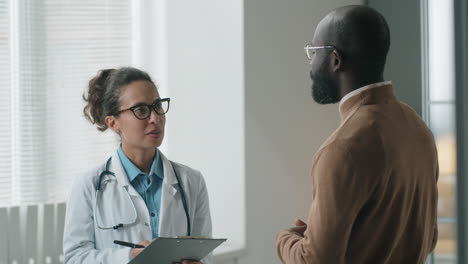 doctora hablando con un paciente afroamericano en la clínica