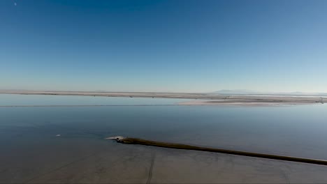 un dron que vuela sobre las salinas de bonneville muestra la calzada de las salinas y la salina inundada