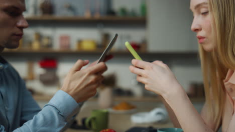 una pareja escribiendo teléfonos inteligentes ignorándose el uno al otro en casa de cerca. familia infeliz.