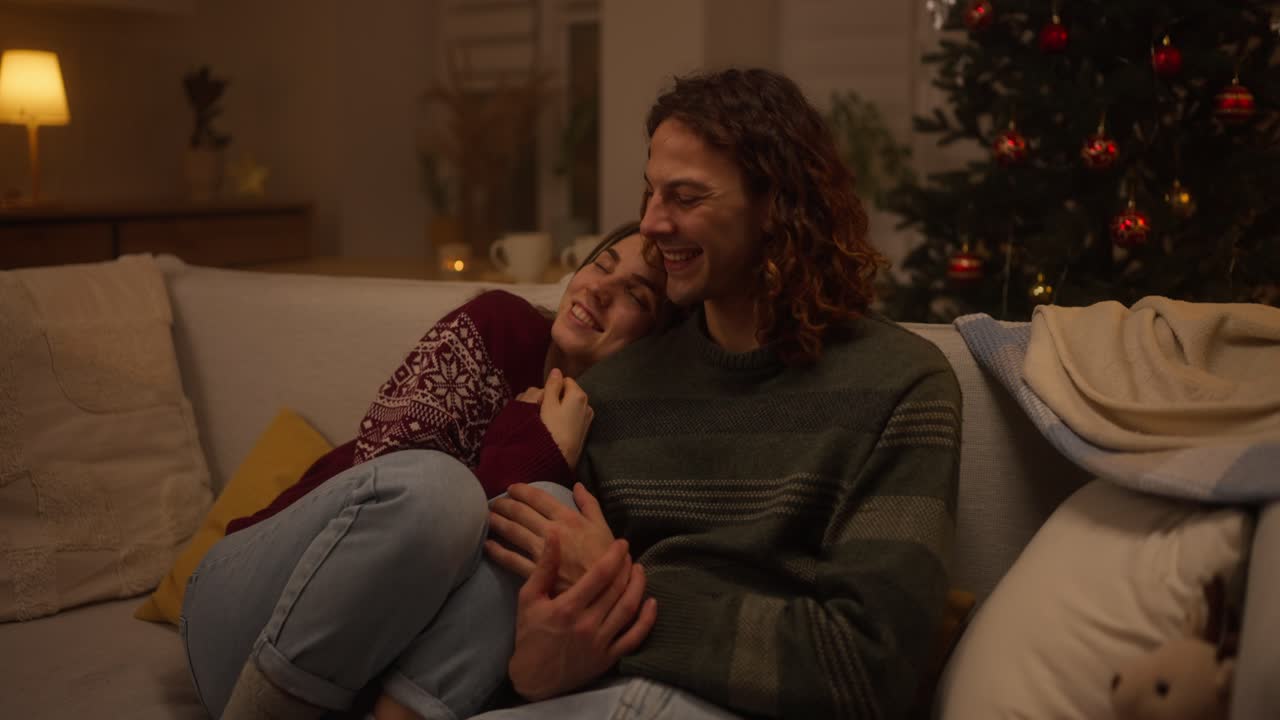 Coppia che si rilassa sul divano a Natale