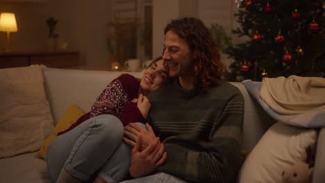 couple relaxing on sofa during christmas
