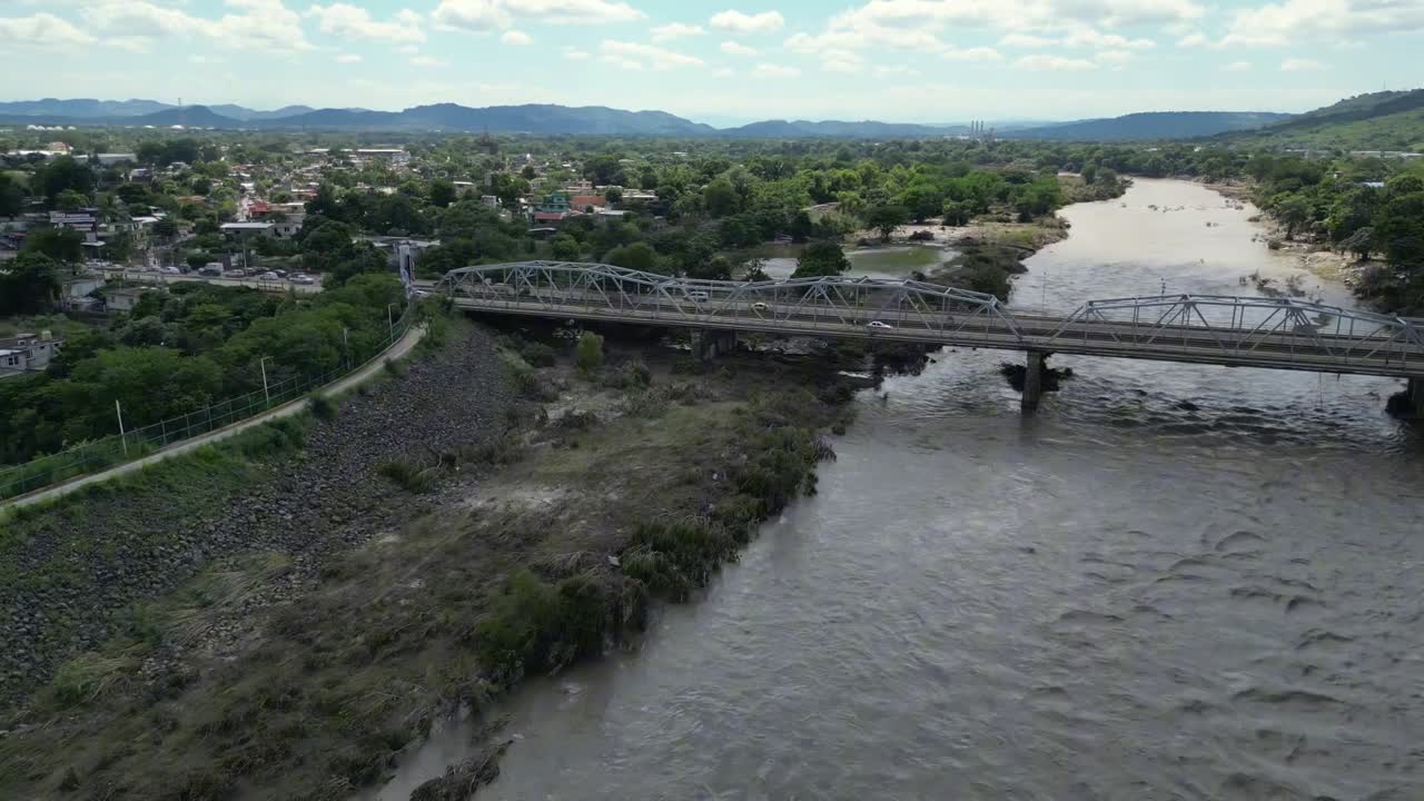 toma panorámica con dolly, coches puente y río después de los efectos de la inundación en México