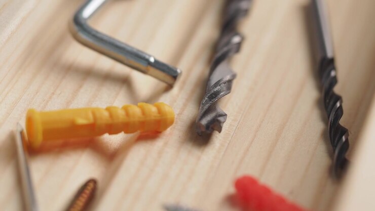 Assortment of DIY Tools and Fasteners on a Wooden Surface