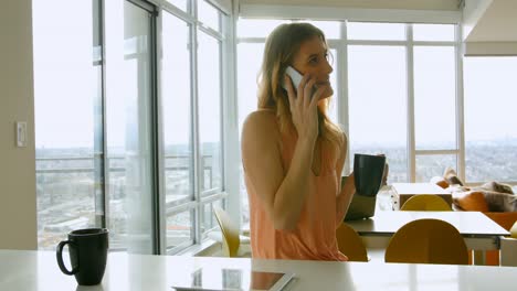 Woman-talking-on-mobile-phone-while-having-coffee-4k