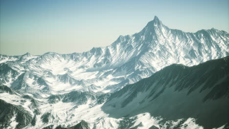 majestic snow covered peaks rise under a clear blue sky in winter wonderland