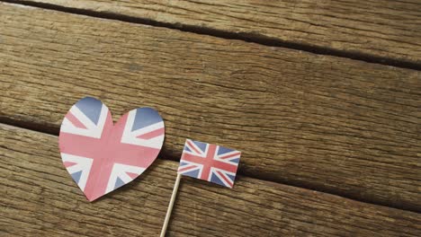 Video-Von-Flaggen-Großbritanniens-In-Form-Eines-Herzens-Und-Eines-Rechtecks-Auf-Holzhintergrund
