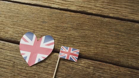 video of flags of great britain in shape of heart and rectangle on wooden background