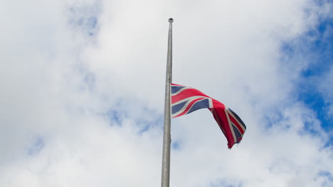 cámara lenta ondeando a media asta de la bandera union jack en cornualles mientras la nación del reino unido llora la muerte de la reina isabel ii