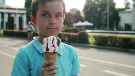 Nahaufnahme-Eines-Kleinen-Jungen,-Der-Eis-Isst.-Entspanntes-Kind,-Das-Im-Vergnügungspark-Spaziert