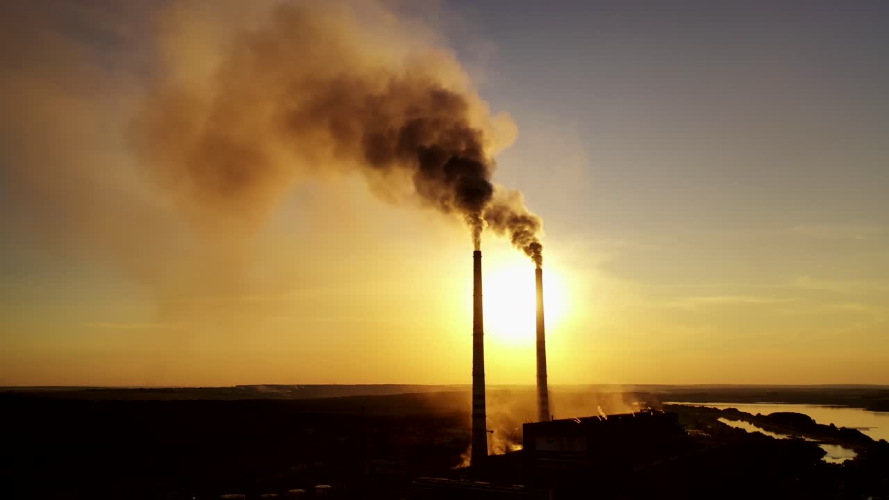 Aerial view over power plant. Aerial view of powerplant with smoke coming out of the chimneys