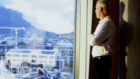businessman looking outside the window in hotel room 4k