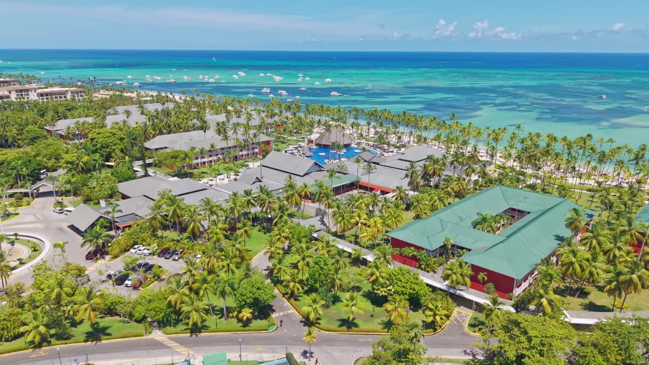 Luxury Beachfront Hotel And Resort With Palm Trees By The Blue Sea In Punta Cana, Dominican Republic. - aerial shot