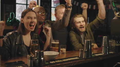 friends watching sports game at bar