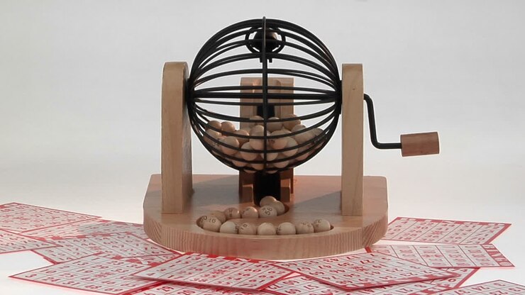 A bingo cage and balls sit on top of bingo cards