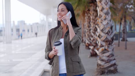 Young-woman-chatting-on-a-mobile-on-an-esplanade