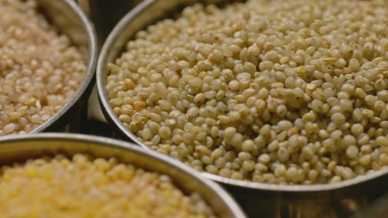 types of healthy millet grains, stored in the steel bowls, 4k, close up shot