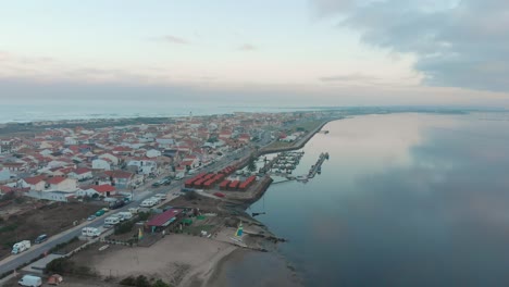 Vista-Aérea-De-Un-Pequeño-Pueblo-Entre-El-Océano-Y-El-Río