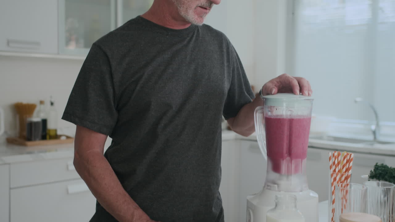 Portrait of Mature Man Making Fruit Smoothie at Home Kitchen
