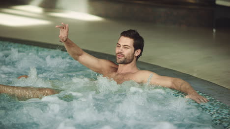 Hombre-Atractivo-Descansando-Bañera-De-Hidromasaje-Interior.-Hombre-Feliz-Relajándose-En-La-Piscina.