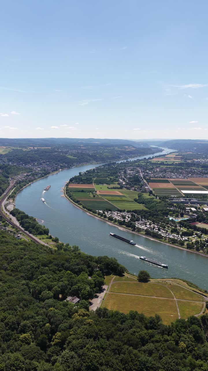Vertical video of the rhine river in Germany. Remagen. Inland schipping, green hills. Aerial