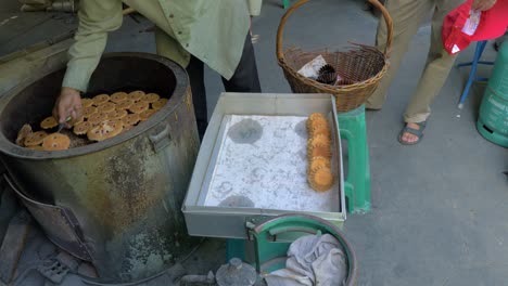 Mano-De-Hombre-Sacando-Pasteles-Tailandeses-Tradicionales-Del-Horno-Y-Colocándolos-En-Bandeja,-Cámara-Lenta