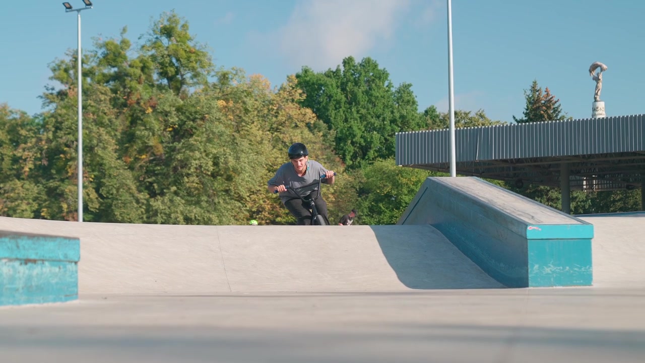 Giovane uomo in bici BMX che salta una rampa in uno skatepark