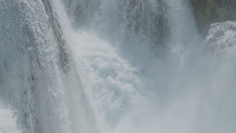 a waterfall with a large amount of water on a clean and wild mountain river