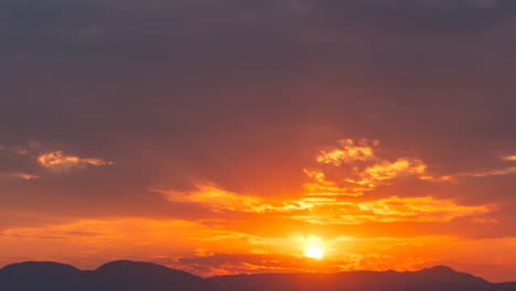 Una-Impresionante-Y-Colorida-Puesta-De-Sol-Más-Allá-De-Las-Montañas-Del-Desierto-De-Mojave-Con-Rayos-Dorados-Filtrándose-A-Través-Del-Paisaje-Nuboso---Lapso-De-Tiempo-Estático