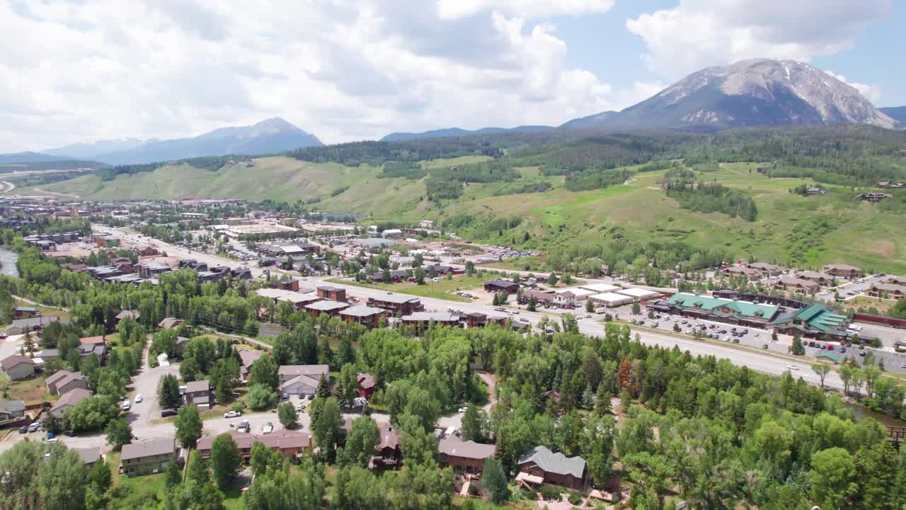 This is an aerial video of the city of Silverthorne, Colorado. Drone flies towards the city and mountains can be seen in the distance.