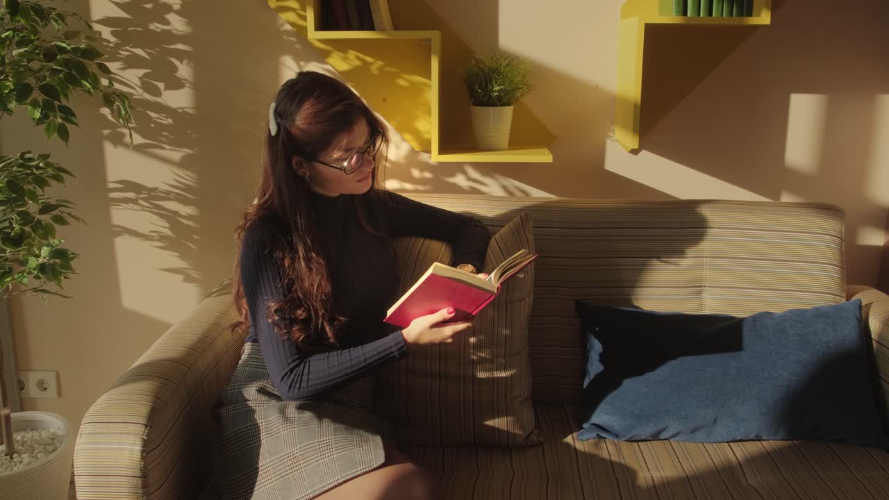 mujer leyendo un libro en un sofá