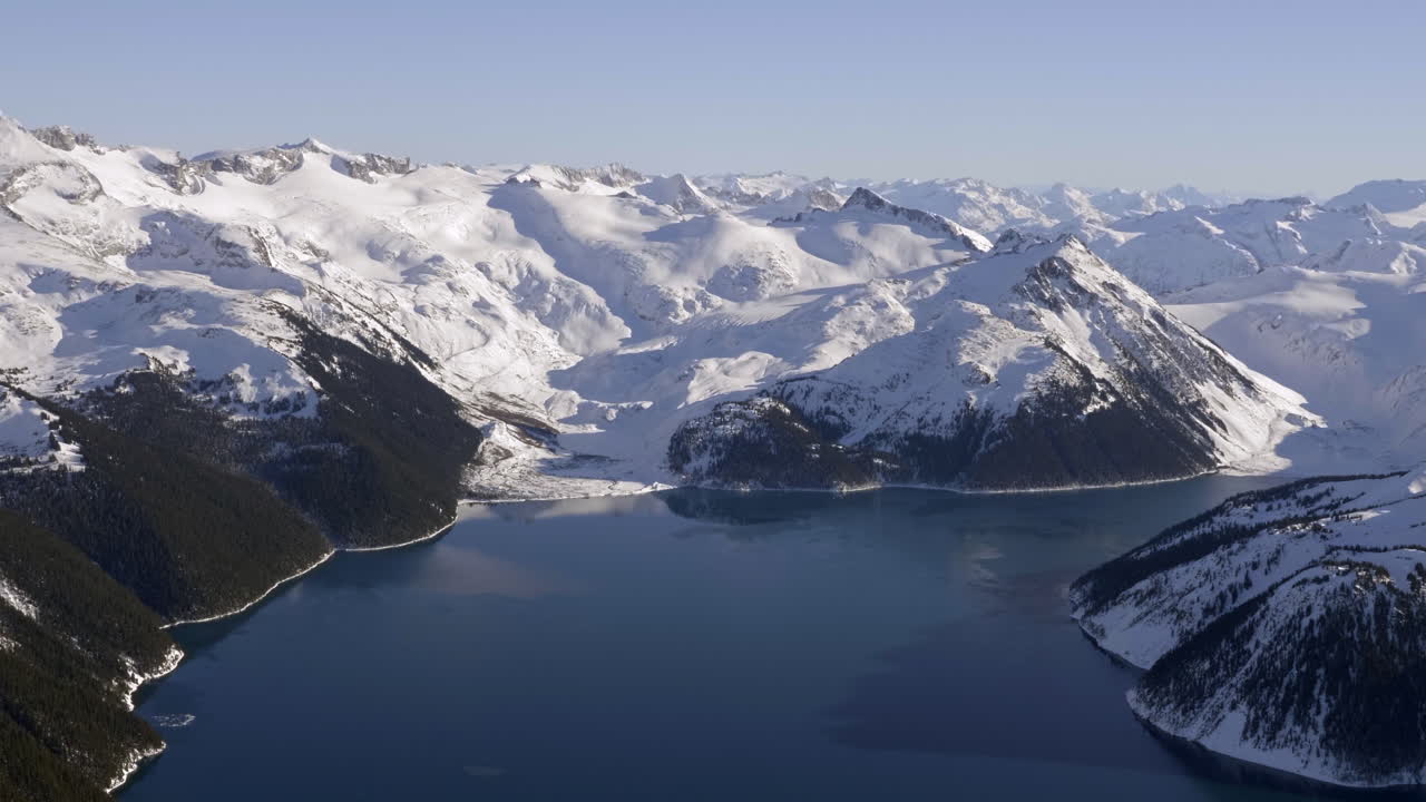 cordillera cubierta de nieve con un lago tranquilo en vancouver, canadá.