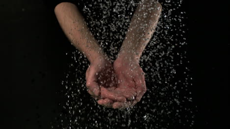 man washing hands under water