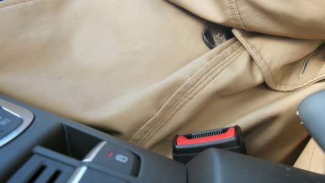 young woman fastening her safety belt in a car