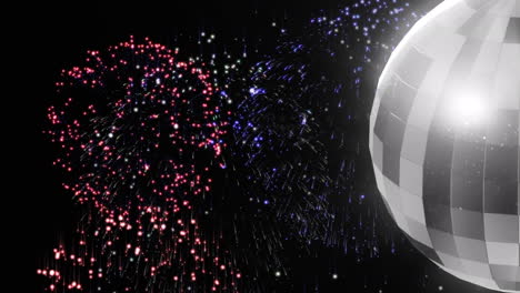 animation of colourful fireworks and rotating mirror ball on black background