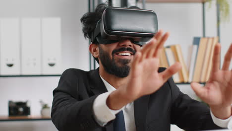 young business man in vr goggles watch virtual reality video working on simulation game at office