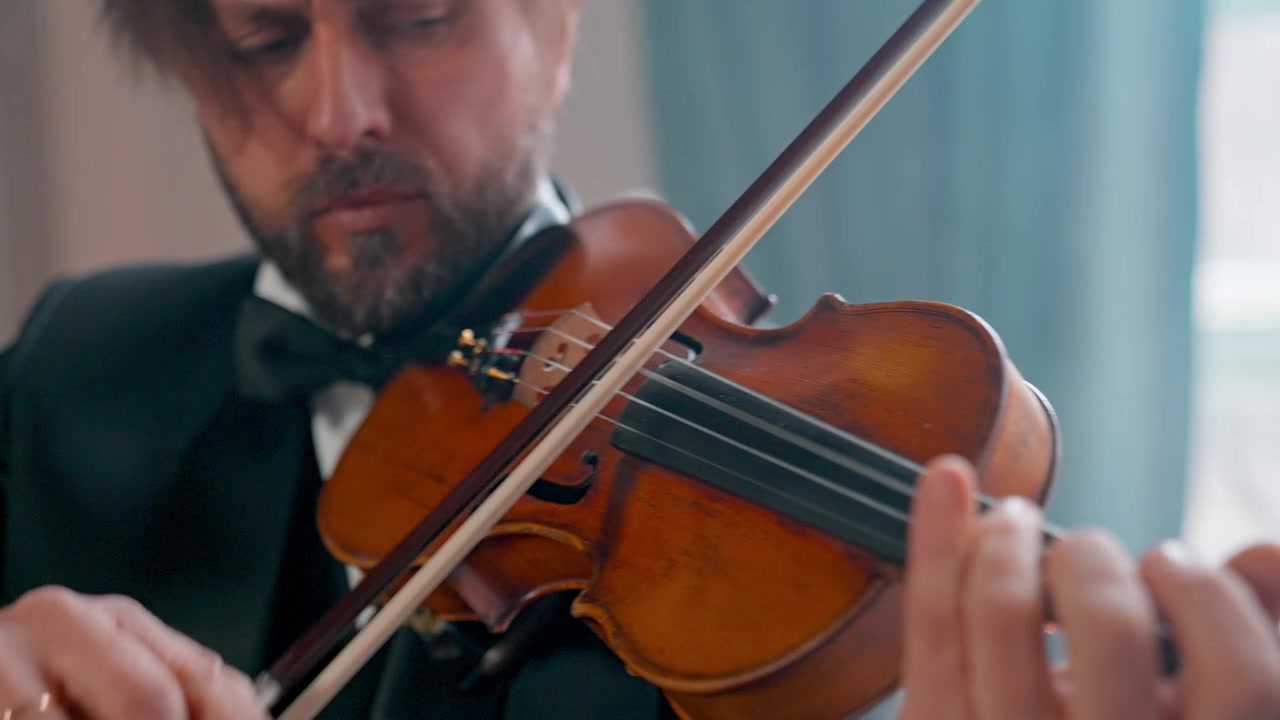 Primo piano di un musicista professionista che suona il violino classico con l'archetto