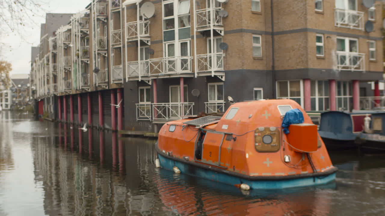 Panning shot following orange boat in Little Venice Regents Canal, London