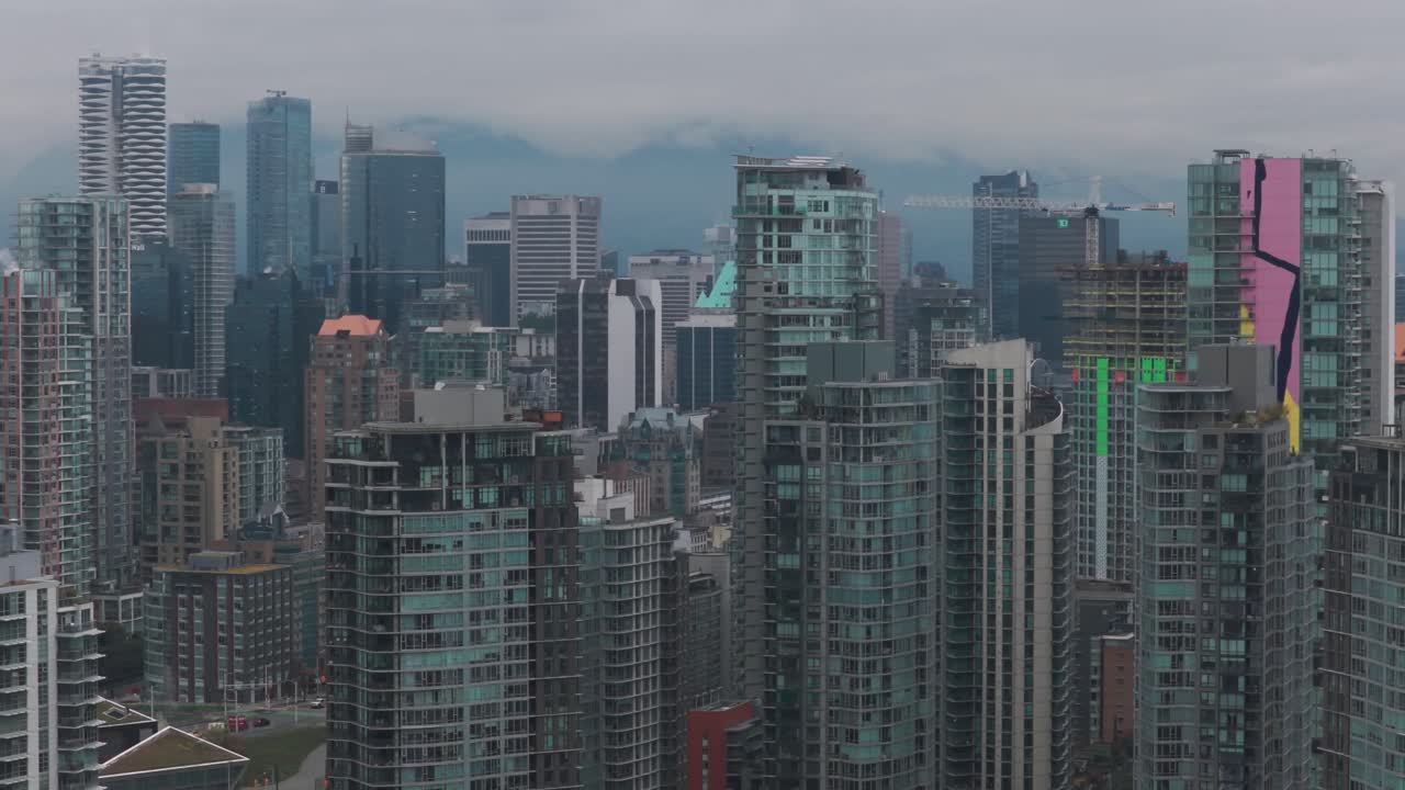 Aerial telephoto dolly shot of skyscrapers in downtown Vancouver on a rainy day in British Columbia, Canada. 4K