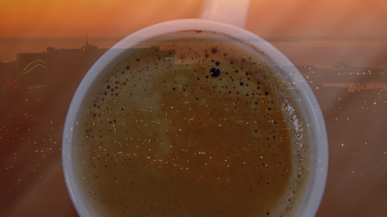 Hand nudging ceramic cup, cup sliding right while crema bubbles drifting, revealing dusk skyline