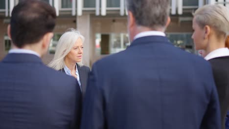 a group of business professionals in an outdoor discussion