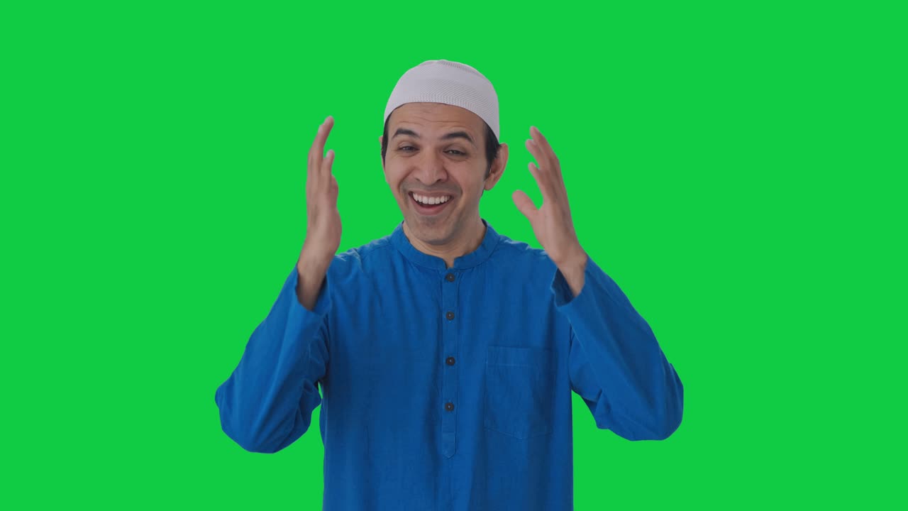 카메라에 웃는 행복한 무슬림 남자 녹색 화면