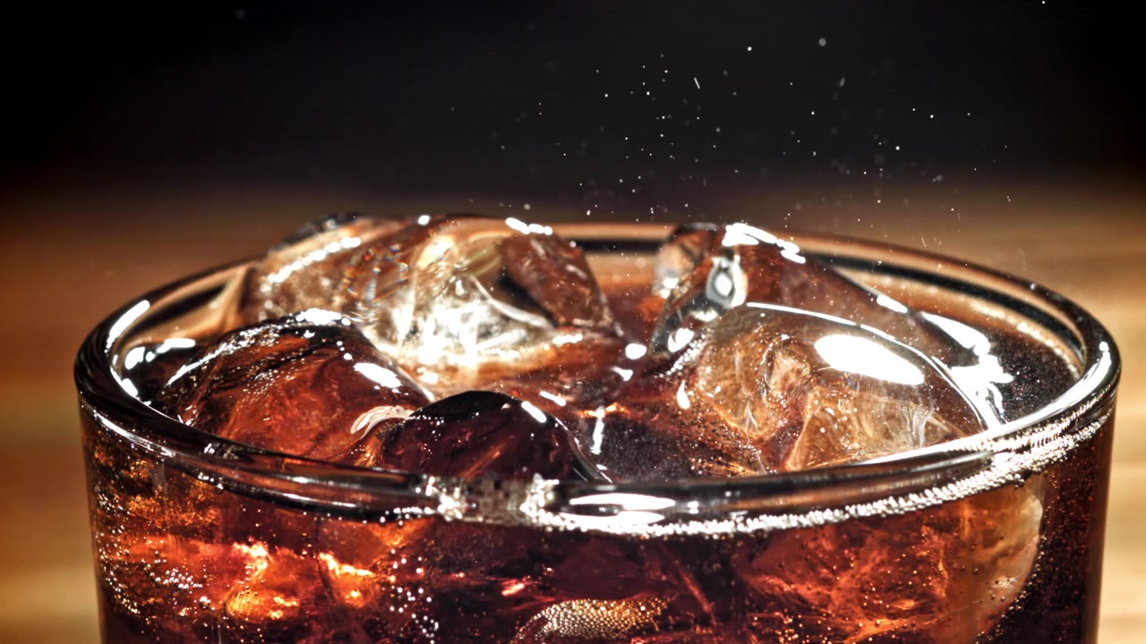 Primo piano di cola rinfrescante con ghiaccio e bollicine